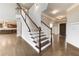 Beautiful staircase with wood and white trim, open to foyer and kitchen at 6145 Grindle Rd, Cumming, GA 30041