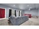 Basement features a grey sectional sofa, red accent furniture, and two windows with black curtains at 3423 Mulberry Lane Ct, Dacula, GA 30019