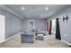 Finished basement with a grey sectional sofa and ottoman with a window at 3423 Mulberry Lane Ct, Dacula, GA 30019