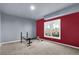 Finished basement space with neutral walls, carpet, workout bench, and a window for natural light at 3423 Mulberry Lane Ct, Dacula, GA 30019