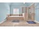 Bright bathroom with a soaking tub and separate shower with decorative tile surround at 3423 Mulberry Lane Ct, Dacula, GA 30019