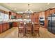 Well-lit eat-in kitchen with granite countertops, dark wood cabinets, and stainless steel appliances at 3423 Mulberry Lane Ct, Dacula, GA 30019