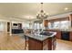 Open kitchen with granite island, wood cabinets, and adjacent living space at 3423 Mulberry Lane Ct, Dacula, GA 30019