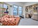 Cozy bedroom with a stylish chaise lounge, built-in desk, and abundant natural light at 240 Renaissance Pkwy # 116, Atlanta, GA 30308