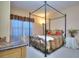 Comfortable bedroom featuring a four-poster bed, soft lighting, and window at 240 Renaissance Pkwy # 116, Atlanta, GA 30308