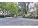 Gated entrance with brick pillars leads to a community with tree-lined streets and manicured landscaping at 240 Renaissance Pkwy # 116, Atlanta, GA 30308