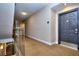 Wide neutral hallway leading to the entrance door and a staircase with a white railing at 240 Renaissance Pkwy # 116, Atlanta, GA 30308