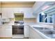 Features a clean kitchen with white cabinets and countertops, with stainless steel appliances at 240 Renaissance Pkwy # 116, Atlanta, GA 30308