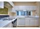 Classic kitchen features white cabinetry, countertops, and appliances, enhanced by natural light at 240 Renaissance Pkwy # 116, Atlanta, GA 30308