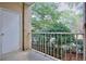 Cozy outdoor patio featuring an iron railing and a view of mature trees and greenery at 240 Renaissance Pkwy # 116, Atlanta, GA 30308