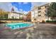 Large community pool with ample seating and mature landscaping beside a multi-story complex at 240 Renaissance Pkwy # 116, Atlanta, GA 30308