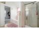 Bright bathroom with a shower, bathtub, and a doorway into a spacious walk-in closet at 6476 Snowden Dr, Atlanta, GA 30349
