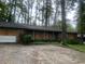 Brick ranch house with boarded windows, needs renovation. Located on a wooded lot at 2328 Columbia Dr, Decatur, GA 30032