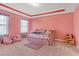 Whimsical bedroom featuring pink walls, a cozy daybed, and various plush toys, creating a playful and inviting space at 189 Osier Dr, Mcdonough, GA 30252