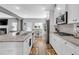 Open-concept kitchen featuring granite counters, stainless steel appliances, and an island with a sink and breakfast bar at 189 Osier Dr, Mcdonough, GA 30252