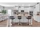 An airy kitchen with white cabinets, granite countertops, stainless steel appliances, and a large central island with bar stools at 189 Osier Dr, Mcdonough, GA 30252