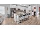 Modern kitchen featuring white cabinetry, stainless steel appliances, a large granite island with seating and light wood floors at 189 Osier Dr, Mcdonough, GA 30252