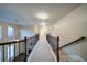 Second floor hallway featuring wood and metal railings, and neutral carpeting at 4280 Hunters Walk Way, Cumming, GA 30028