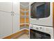 A conveniently stacked washer and dryer sit beside ample shelving in this laundry room at 208 Kenninghall Ln # 627, Smyrna, GA 30082