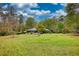 Picturesque backyard featuring a spacious lawn, pool, and mature trees, offering a serene and private outdoor space at 110 Cove Ln, Social Circle, GA 30025