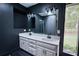 Bathroom with a double sink vanity, dark walls, and tile floors at 110 Cove Ln, Social Circle, GA 30025
