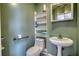 Cozy bathroom featuring built in shelving beside the toilet and pedestal sink at 110 Cove Ln, Social Circle, GA 30025