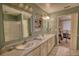 Bathroom featuring dual sinks, a vanity and a large mirror, and a shower with sliding glass doors at 110 Cove Ln, Social Circle, GA 30025