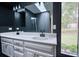 Bathroom with a double sink vanity, dark walls, and tile floors at 110 Cove Ln, Social Circle, GA 30025
