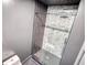 Bathroom featuring a gray tiled shower and toilet at 110 Cove Ln, Social Circle, GA 30025