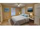 Cozy bedroom with a ceiling fan, natural light, and a large bed in front of two windows at 110 Cove Ln, Social Circle, GA 30025