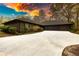 Charming single-story home showcasing a spacious driveway with lush bushes at 110 Cove Ln, Social Circle, GA 30025