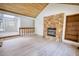 Living room boasting a stone fireplace, wood ceiling, and light modern flooring at 110 Cove Ln, Social Circle, GA 30025