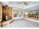 Cozy living area with vaulted ceiling, light wood floors, stone fireplace, and a view into the kitchen at 110 Cove Ln, Social Circle, GA 30025