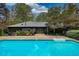 Backyard pool area with fencing, landscaping, and surrounding mature trees at 110 Cove Ln, Social Circle, GA 30025