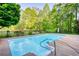 Sparkling pool surrounded by lush landscaping, creating a serene and private backyard oasis at 110 Cove Ln, Social Circle, GA 30025