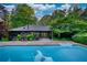 Back of home features a large in-ground pool, concrete patio and beautiful landscaping at 110 Cove Ln, Social Circle, GA 30025