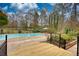 Featuring an in-ground pool and a deck area with surrounding trees and plants with privacy and space at 110 Cove Ln, Social Circle, GA 30025