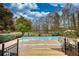 Backyard in-ground pool with surrounding trees and a deck that leads to it, providing privacy and space at 110 Cove Ln, Social Circle, GA 30025