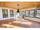 Bright sunroom features wood ceiling, wood-look floors, and large windows offering plenty of natural light and a pool view at 110 Cove Ln, Social Circle, GA 30025