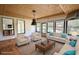 This virtually staged sunroom features wood ceiling, wood-look floors, and large windows offering a pool view at 110 Cove Ln, Social Circle, GA 30025