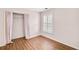 Cozy bedroom with hardwood floors, a closet with pink curtains, and a shuttered window at 120 Mill Creek Dr, Canton, GA 30115