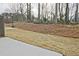 Well-maintained backyard with newly planted lawn, mulch and mature trees at 697 Sunstone Ln, Lawrenceville, GA 30043