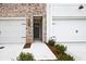 Attractive townhome exterior with a two-car garage and landscaped front yard at 697 Sunstone Ln, Lawrenceville, GA 30043