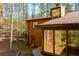 View of the home's wood exterior, complemented by a stone chimney and lush natural surroundings at 4771 Cool Springs Rd, Winston, GA 30187