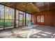 An enclosed porch with wooden framing, a concrete floor, and a clear view of the surrounding greenery at 4771 Cool Springs Rd, Winston, GA 30187
