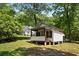 A quaint building with a porch is nestled among mature trees, creating a peaceful and secluded ambiance at 291 Miquel Jorge Ln, Canton, GA 30115