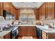 Charming kitchen features custom wood cabinets, granite countertops, stainless appliances, and wood floors at 291 Miquel Jorge Ln, Canton, GA 30115