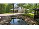 Scenic backyard pond with rock borders and lush landscaping, set against a charming home at 291 Miquel Jorge Ln, Canton, GA 30115