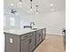 Modern kitchen island with gray cabinets and quartz countertops at 717 Trevett Way, Marietta, GA 30062