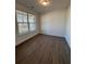 A bright bedroom featuring wood-look flooring, a window with blinds, and neutral paint at 2280 Highridge Point Dr, Lithia Springs, GA 30122